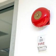 A red fire alarm on a white wall Description automatically generated